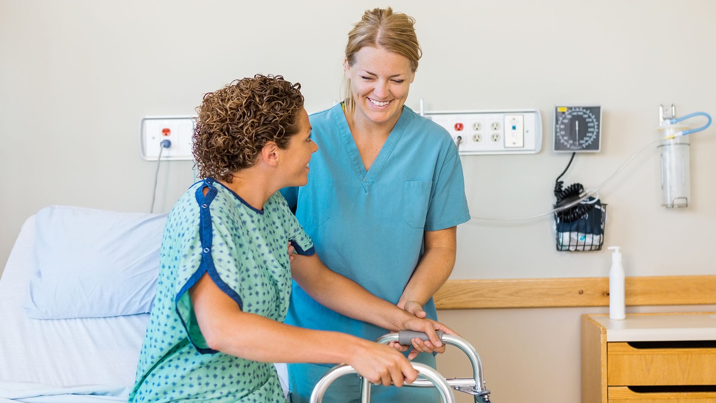 Image of a nursing assistant providing care to a patient.